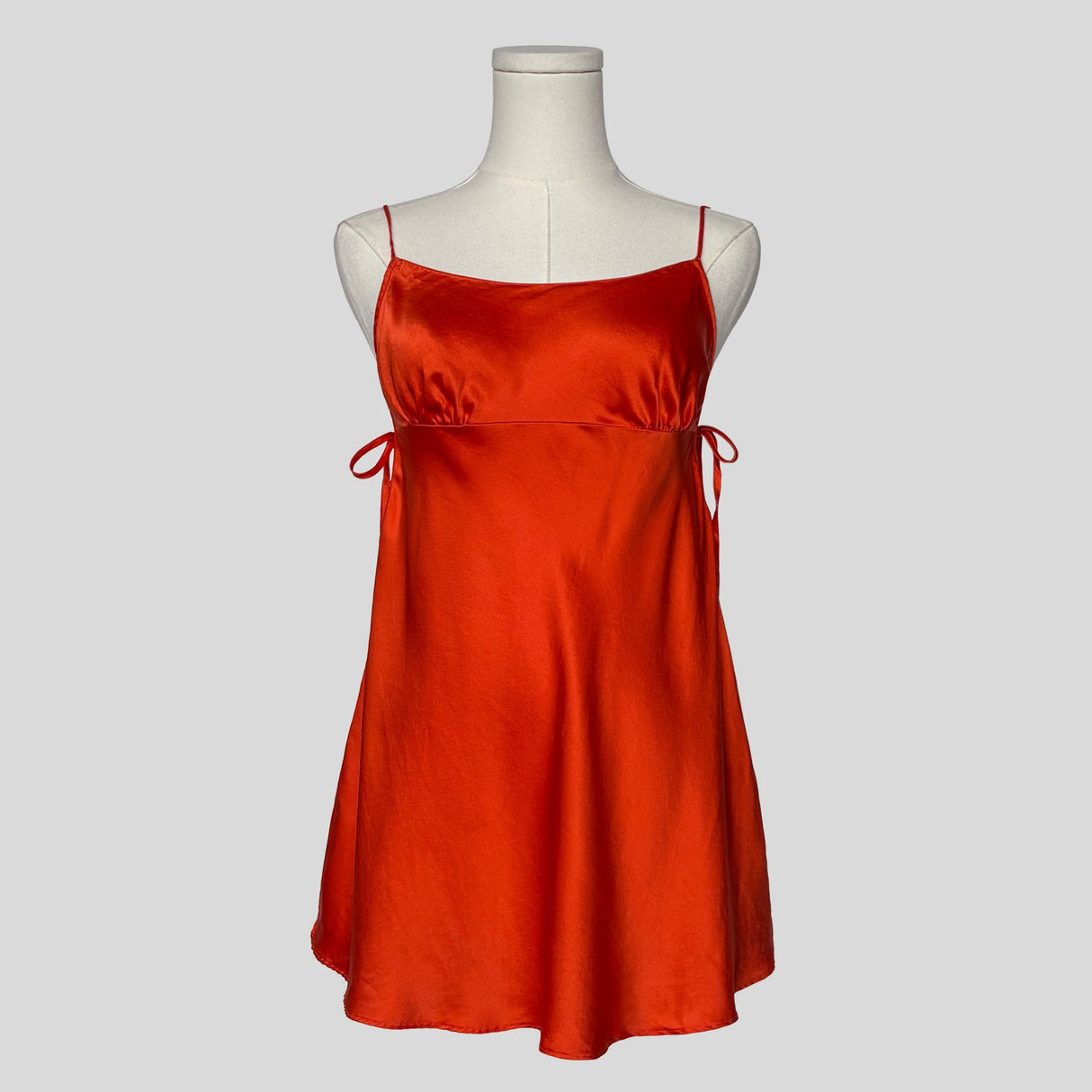 Silk slip dress with side cutouts and bows in orange