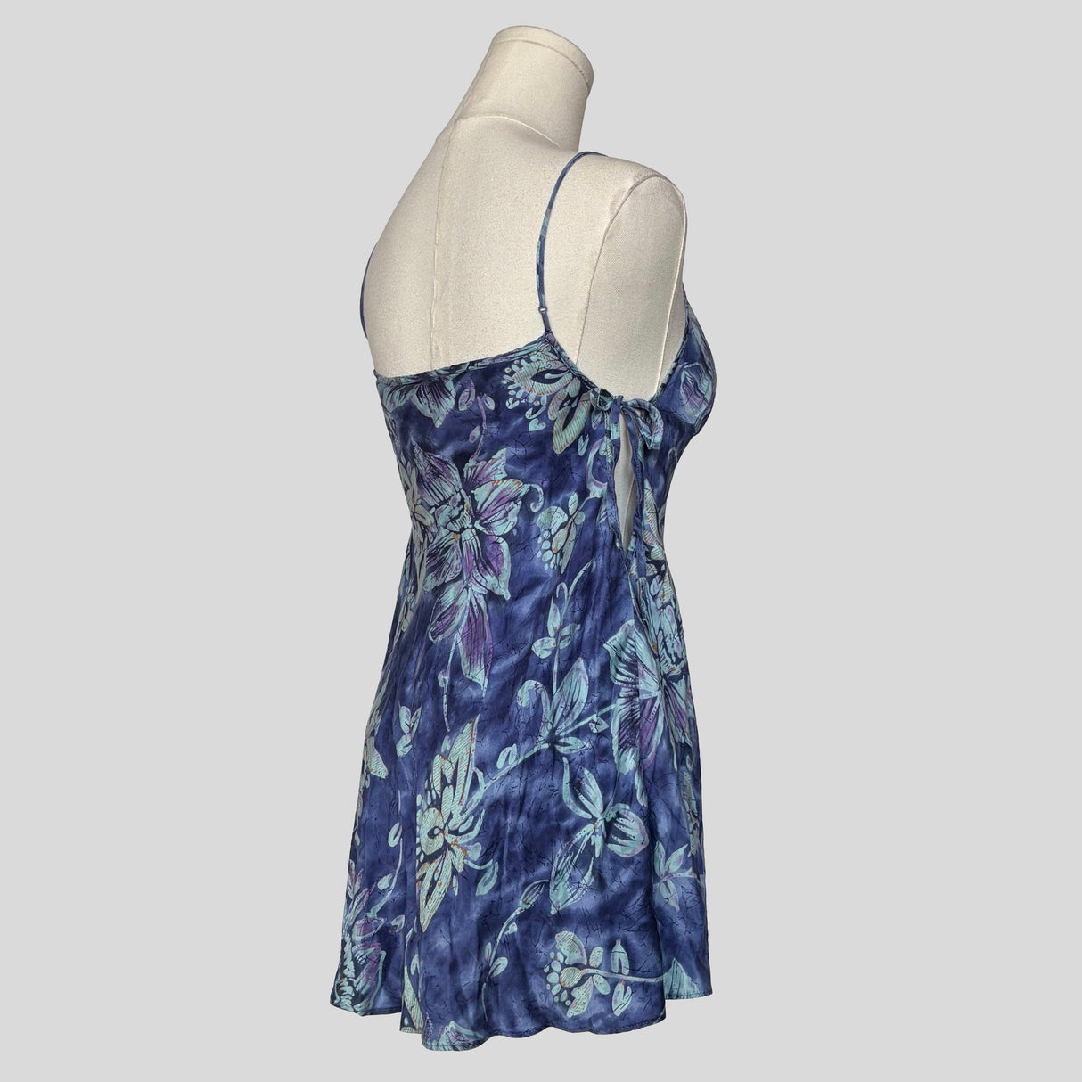 Silk slip dress with side cutouts and bows in blue floral