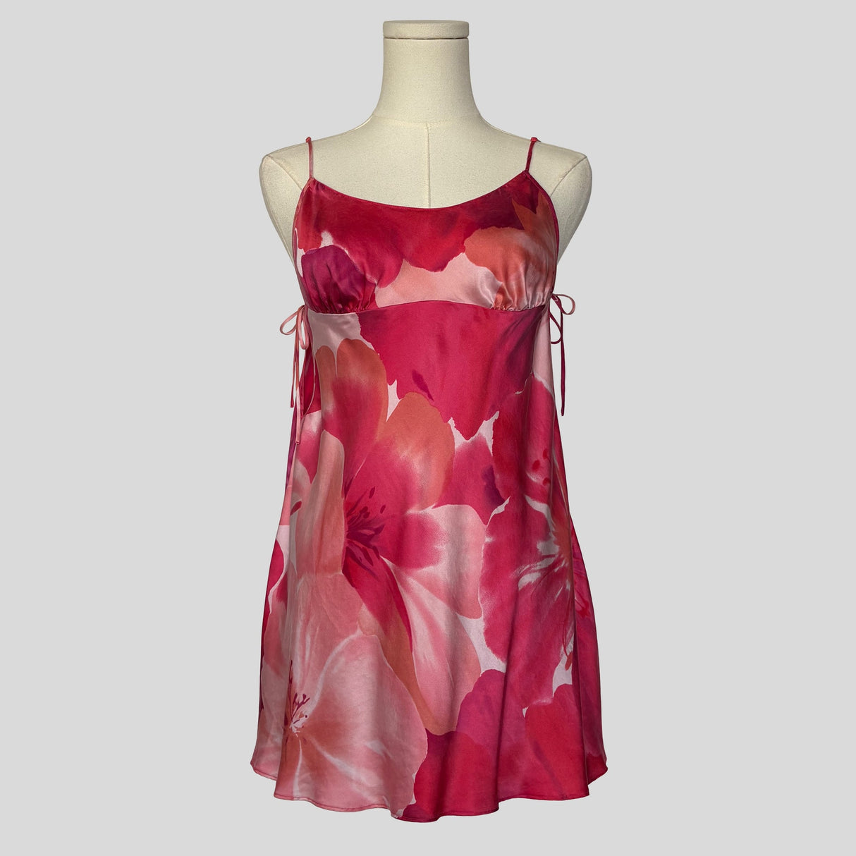 Silk slip dress with side cutouts and bows in pink floral