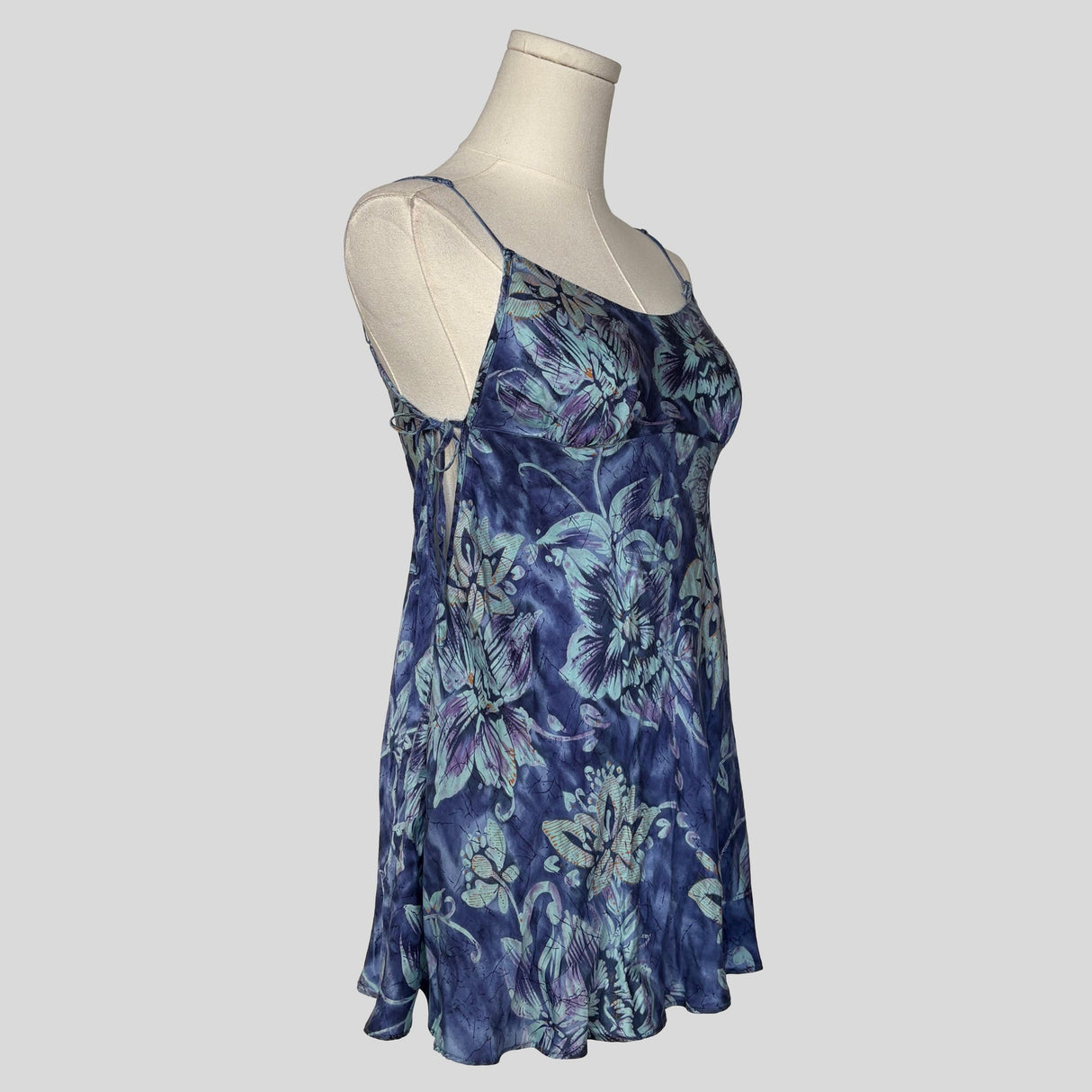 Silk slip dress with side cutouts and bows in blue floral
